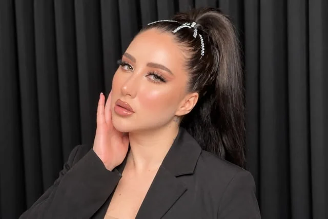 High ponytail with a silver bow and soft occasion makeup