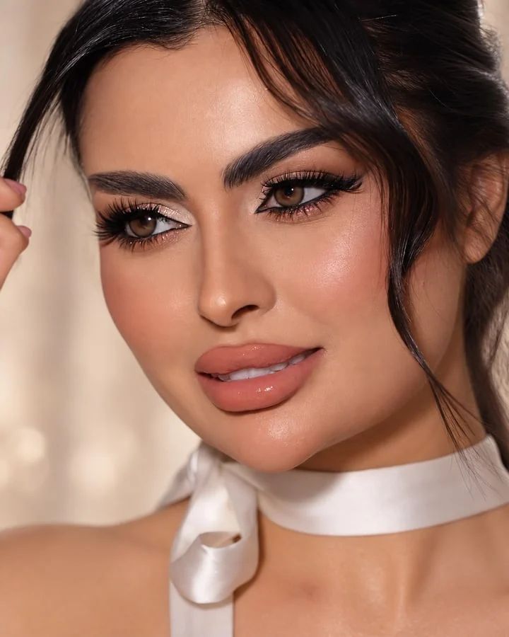 Close view of luminous bridal makeup with defined eyes and a glossy nude lip