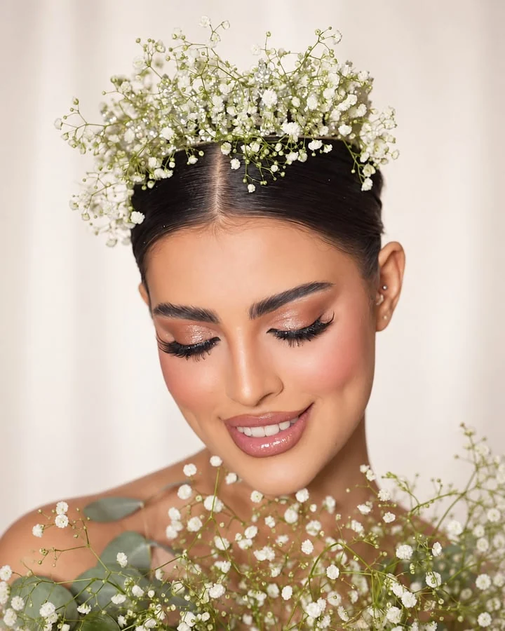 Soft bridal makeup framed by delicate white flowers